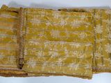 three pieces of yellow fabric with white flowers and fringes