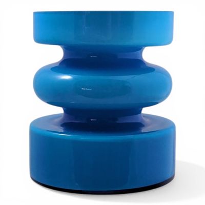 the large blue vase is sitting on top of a white table