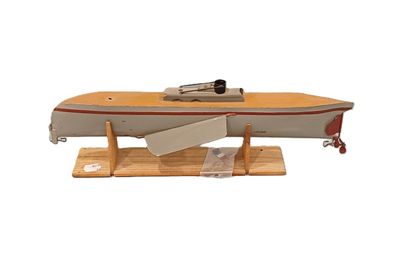 un petit bateau en bois avec une pagaie posée sur un support