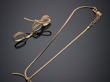 une paire de boucles d'oreilles en or et un collier en or sur fond noir