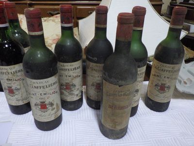Plusieurs bouteilles de vin sont alignées sur une table devant un miroir.