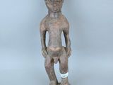 une vieille statue en bois d'un homme avec un chapeau sur la tête