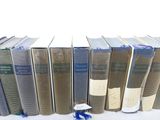 several books are lined up in a row on a white surface