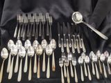 un grand nombre de cuillères et de fourchettes disposées sur une table