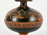 a black and gold vase with a design on it