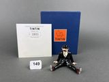 an image of a figurine of a man sitting on the ground next to a book