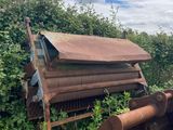 a rusted out machine sitting in the middle of a field