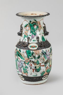 un vase avec un tableau posé sur une table