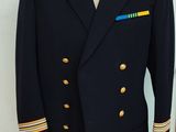 navy officer ' s coat with gold buttons on a mannequin stand