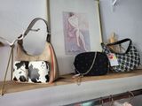 two purses on a shelf next to a mirror
