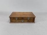 une petite boîte en bois surmontée de deux tiroirs