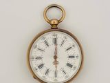 a gold pocket watch with roman numerals on the face