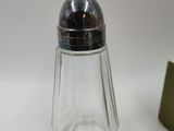 une image représentant un ensemble de sel et de poivre en verre muni d'un couvercle en métal