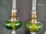 two green glass lamps with gold trims on each of them