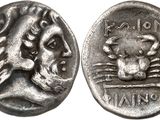 a close up of a silver coin with a skull on it