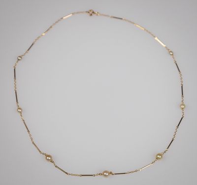 un collier en or orné de perles sur fond blanc