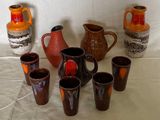 de nombreux vases et tasses de différentes couleurs sur la table
