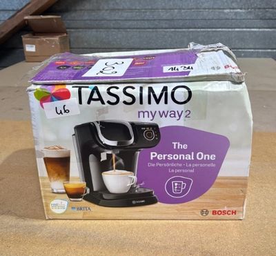 une boîte posée sur une table, sur laquelle se trouve une cafetière