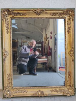 J/ Miroir en bois et stuc doré à décor de blasons en écoinço…