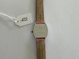 a close up of a watch on a white surface with a price tag