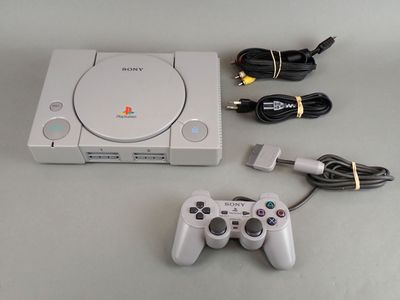 a white game console with a game controller next to it