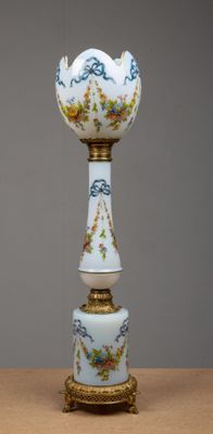 un vase blanc avec un socle doré posé sur une table