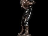 bronze statue of a boy holding a baseball bat on a pedestal