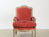 an old chair with red velvet upholstered and gold trim