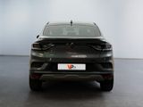 the rear end of a black car in a room with a white wall