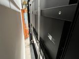 a black refrigerator sitting in the middle of a narrow room