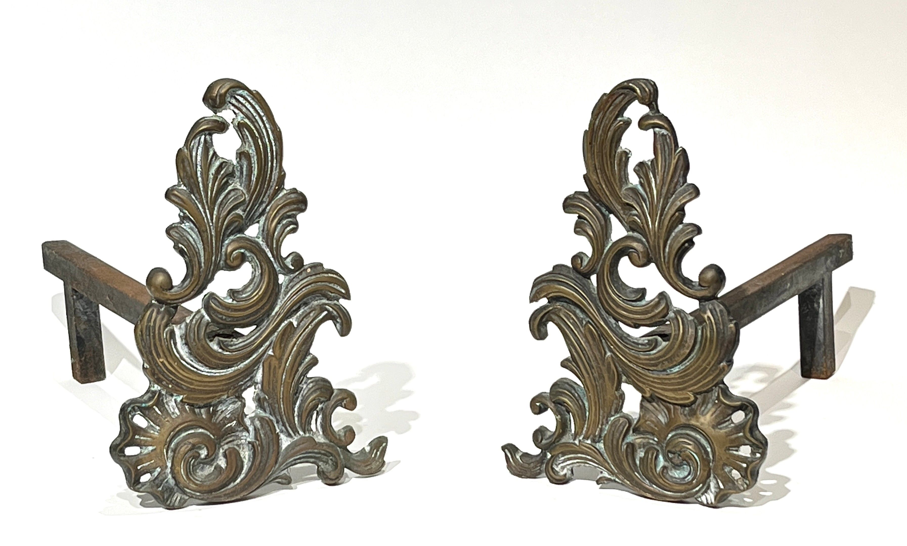 Paire de chenets en bronze à décor de rinceaux feuillagés. Style Louis XV. H. 27 cm.