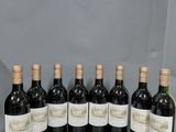 six bouteilles de vin sont alignées sur une étagère