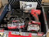 une caisse d'outils avec des outils à l'intérieur, posée sur le sol