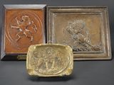 three bronze plaques of lions and a lion on a black background