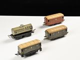 quatre wagons de train miniature sont alignés sur une surface blanche