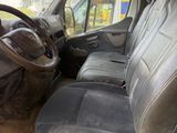une photo d'une camionnette sale dont les sièges avant sont rabattus
