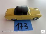 une petite voiture jaune sur laquelle figure un numéro