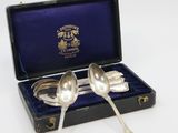 pair of silver plated spoons in a case with blue velvet lining