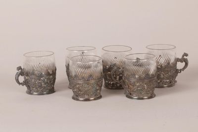 quatre verres à anse sont alignés sur une surface blanche