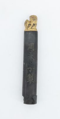 un briquet noir et doré orné d'une tête de lion