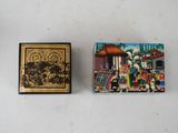 a small box with a painting on it next to a small box with a painting on it