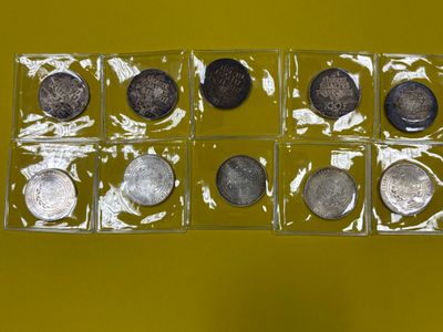 six types de pièces différents dans une boîte transparente posée sur un support jaune