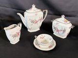 four pieces of tea and coffee set on a table
