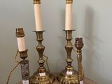Trois bougies sont posées sur une table en bois près d'un mur.