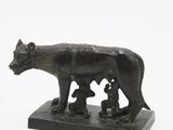 statue of a wolf with two cubs on a base