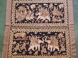 a close up of a black and gold rug on a green floor