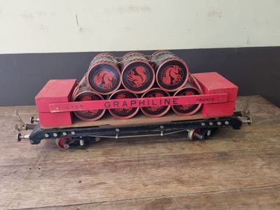 a red train car that has a bunch of rolls on it