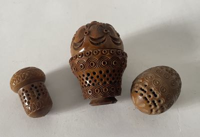 trois petits objets en bois posés sur une surface blanche