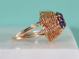 a close up of a gold ring with a purple stone