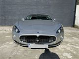 the front of a silver sports car parked in front of a building
